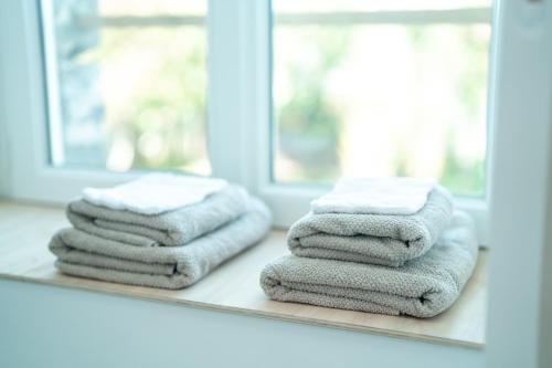 a stack of towels sitting on a counter in front of a mirror at Private Spa and Garden 10 min from Mont St-Michel in Pontorson