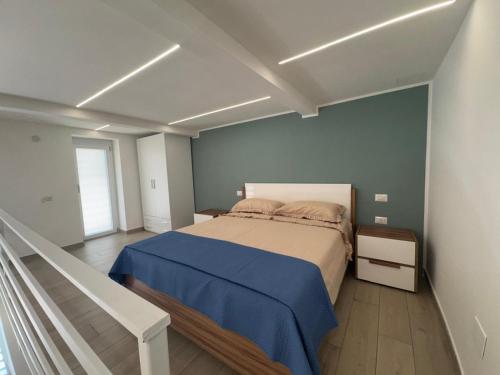 a bedroom with a bed with a blue wall at AparthouseRisorgimento MISENO in Frattamaggiore