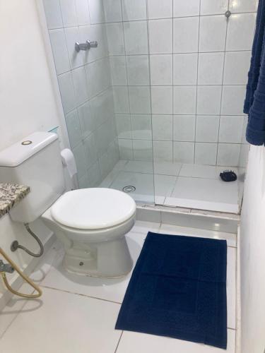 a bathroom with a toilet and a shower with a blue rug at Smart Flat Apart in Mogi das Cruzes
