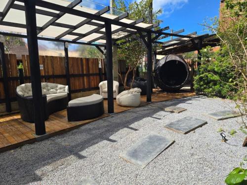 a patio with a pergola and furniture on it at Essência da Guarda Surf House in Guarda do Embaú