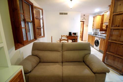 a living room with a couch and a kitchen at El Refugio de la Judería in Córdoba