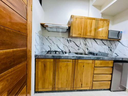 a kitchen with wooden cabinets and a counter top at studio confort in Iquitos