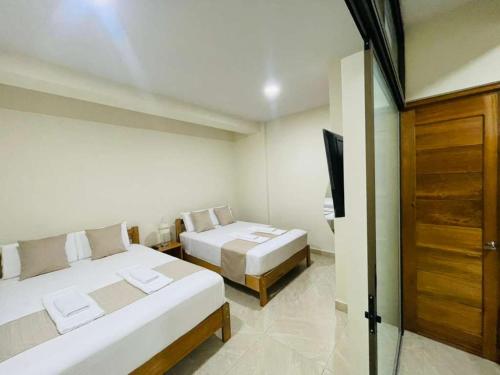 a bedroom with two beds and a television in it at studio confort in Iquitos