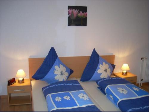a bedroom with two beds with blue and white pillows at Gemütliche Ferienwohnung nähe Wutachschlucht in Hüfingen