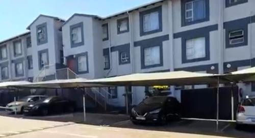 a car parked in a parking lot in front of a building at Peaceful stay in Richards Bay