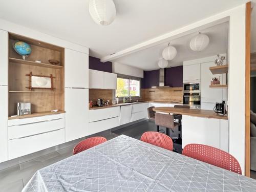 a kitchen with a table and some red chairs at Confort et Bien-être in Désertines