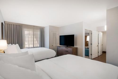 a hotel room with two beds and a flat screen tv at Sonesta ES Suites Anaheim Resort Area in Anaheim