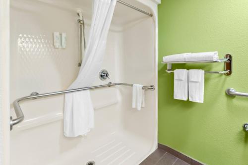 a bathroom with a shower and white towels at Sleep Inn & Suites Princeton I-77 in Princeton