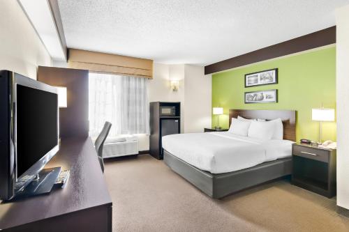 a hotel room with a bed and a flat screen tv at Sleep Inn & Suites Princeton I-77 in Princeton