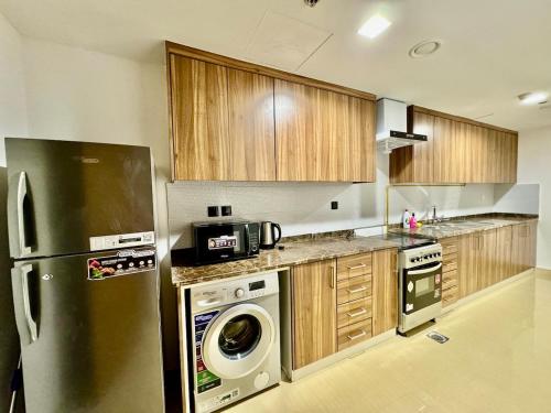 a kitchen with a refrigerator and a washing machine at Deira Luxurious unit near metro in Dubai