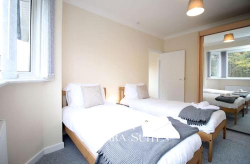ein Zimmer mit zwei Betten und einem Fenster in der Unterkunft 3BR Retreat Near Tredegar & Newport Hub in Rogerstone