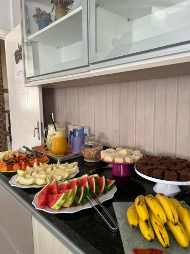 a kitchen counter with many different types of fruits and vegetables at Pousada Mar Azul in Bombinhas