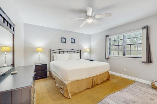a bedroom with a bed and a desk and a window at Seascape Golf Villas 95E in Destin