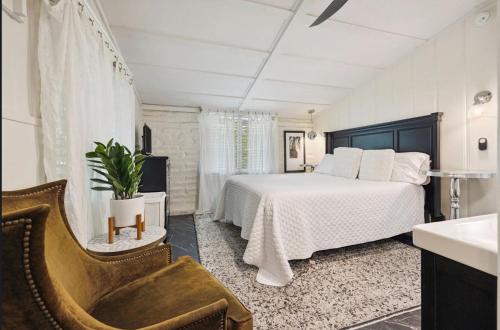 a bedroom with a large bed and a chair at Adobe Cottage at Speakeasy Hotel - Adults Only in Palm Springs