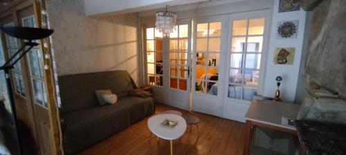 a living room with a couch and a table at Jura entre Lacs et Montagnes Charmant studio cosy de 38 m2 in Orgelet