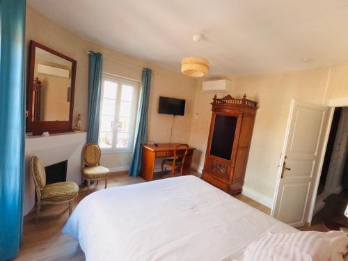 a bedroom with a white bed and a desk at Chambre privée dans maison de ville du XVIIIe siècle in Carbonne