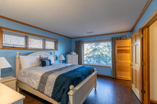 a bedroom with a bed with blue walls and a window at Eagles Rest in Fleetwood