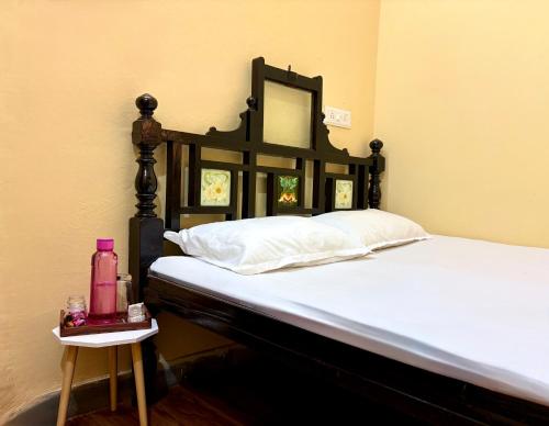 乌贾因Navkar Homestay - Ground Floor 2BHK near Mahakal的一间卧室配有一张带镜子和边桌的床
