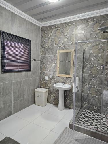 a bathroom with a shower and a sink and a toilet at AB & AB Residence in Burgersfort