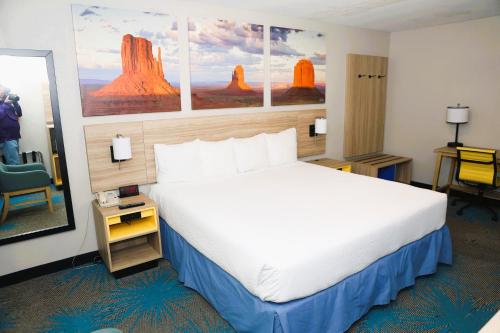a hotel room with a large bed and a chair at Days Inn by Wyndham East Albuquerque in Albuquerque