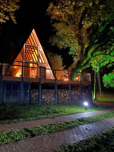 een hut 's nachts met een licht op het gras bij Cabana Álamo-Guimarães Reserva in Cambará