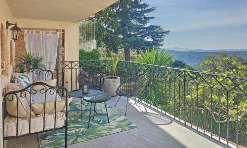 a balcony with chairs and a table and a view at Gîte Le Figuier de Saint Ce - 3 stars - Holiday Home Nature View in Saint-Cézaire-sur-Siagne