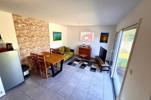 a living room with a dining room table and a brick wall at Bright house with garden in Saint-Sébastien-sur-Loire