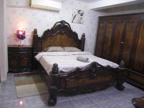 a bedroom with a large wooden bed and a dresser at العين الهيلي مصباح ب 2 in Al Ain
