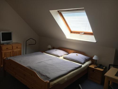 a bedroom with a large bed with a window at Pension Villa Strandläufer in Norddeich