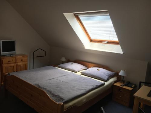 Schlafzimmer mit einem großen Bett und einem Fenster in der Unterkunft Pension Villa Strandläufer in Norddeich