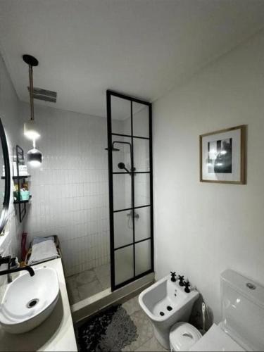 a white bathroom with a toilet and a sink at Chalet House in La Plata in La Plata