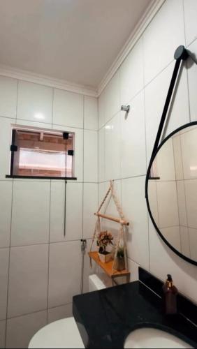 a bathroom with a mirror and a sink at Residencial Recanto dos Colibris in Porto Seguro