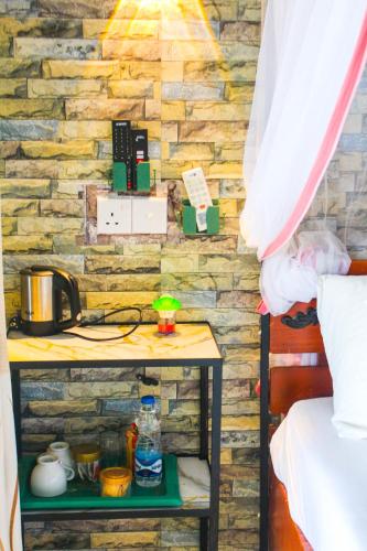 a bedroom with a stone wall with a table next to a bed at Secret View Homestay Ella in Ella