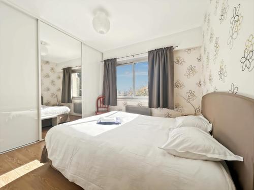 a bedroom with a large white bed and a window at Confort et Bien-être in Désertines