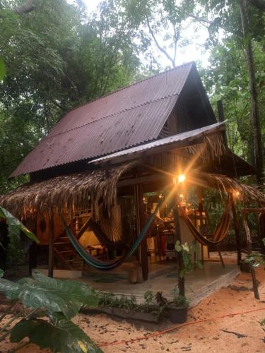 a hut with a hammock in front of it at Casa Embira - 300 metros da Praia do Lago Verde in Alter do Chao
