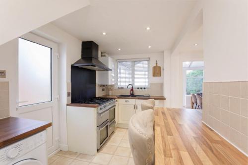 a kitchen with a stove top oven next to a table at Your Home Away From Home - Near York City Centre in York