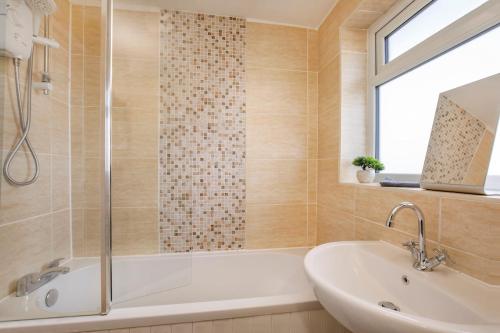 a bathroom with a tub and a sink and a window at Your Home Away From Home - Near York City Centre in York