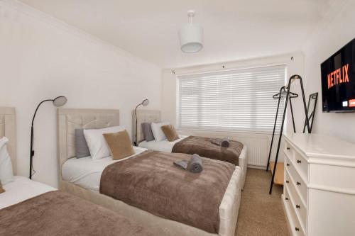 a bedroom with two beds and a television in it at Your Home Away From Home - Near York City Centre in York