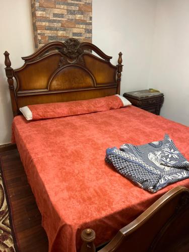 a bed with a red comforter on top of it at A dublex villa in Ghaţāţī