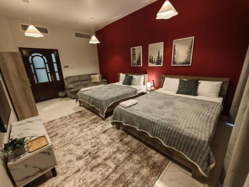 a hotel room with two beds and a couch at TheGrid-Downtown HomeStay Abu Dhabi in Abu Dhabi