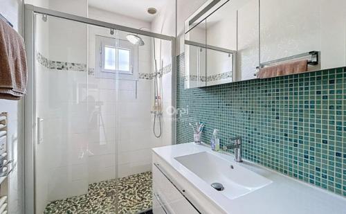 a bathroom with a sink and a glass shower at Confort et Bien-être in Désertines