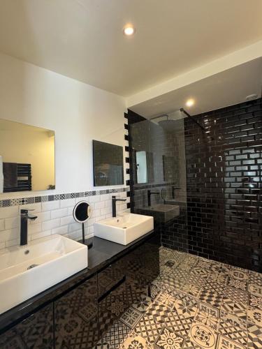 a bathroom with two sinks and a large mirror at Chantilly Spa Lodge near Parc Asterix in Montataire
