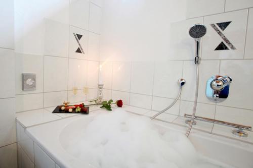 a bathroom with a bath tub with a shower at Hotel Am Hirschhorn - Wellness - Spa - and more in Wilgartswiesen