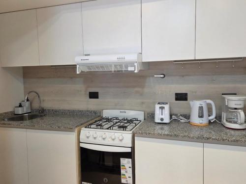 a kitchen with a stove and a counter top at Sol del Atardecer in Rada Tilly