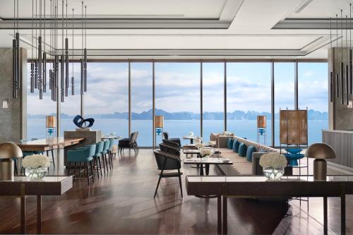 une salle à manger avec vue sur l'eau dans l'établissement InterContinental Halong Bay Resort by IHG, à Hạ Long