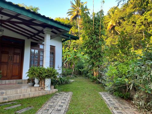 a house with a pathway leading to the front door at Serenique Greens in Peradeniya