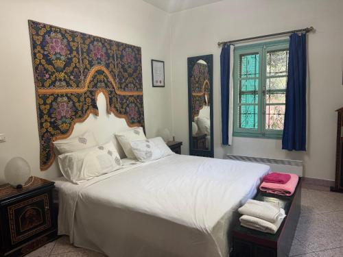 a bedroom with a large white bed and a window at Villa Zaïtoun in Aït Ourir