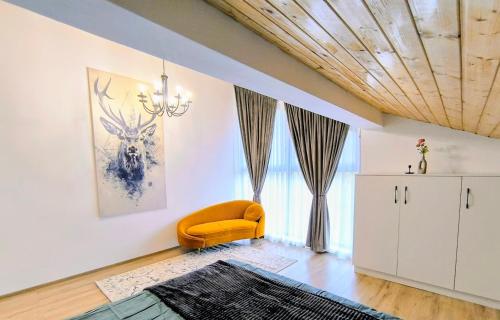 a living room with a yellow chair and a couch at Casa Runcu Dambovita in Bădeni