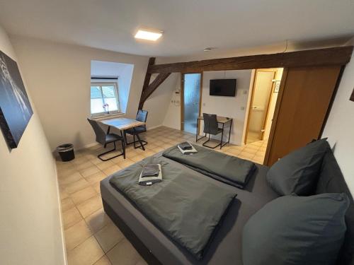 a bedroom with a bed and a table with a laptop at Der OXE am Maindreieck in Niederdorla