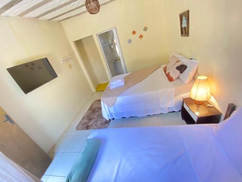 a small room with two beds and a television at Raizes do Cipó in Serra do Cipo